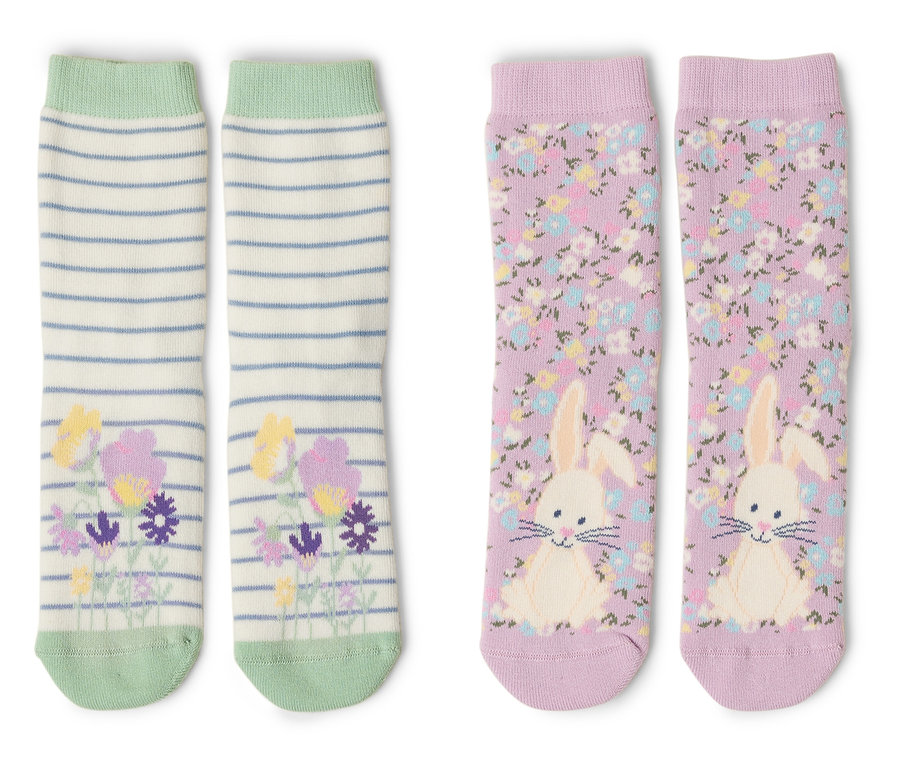 Zwei Paar Socken liegen auf einem weißen Hintergrund. Ein Paar ist gestreift mit Blumen und das andere ist lila mit einem Hasen.