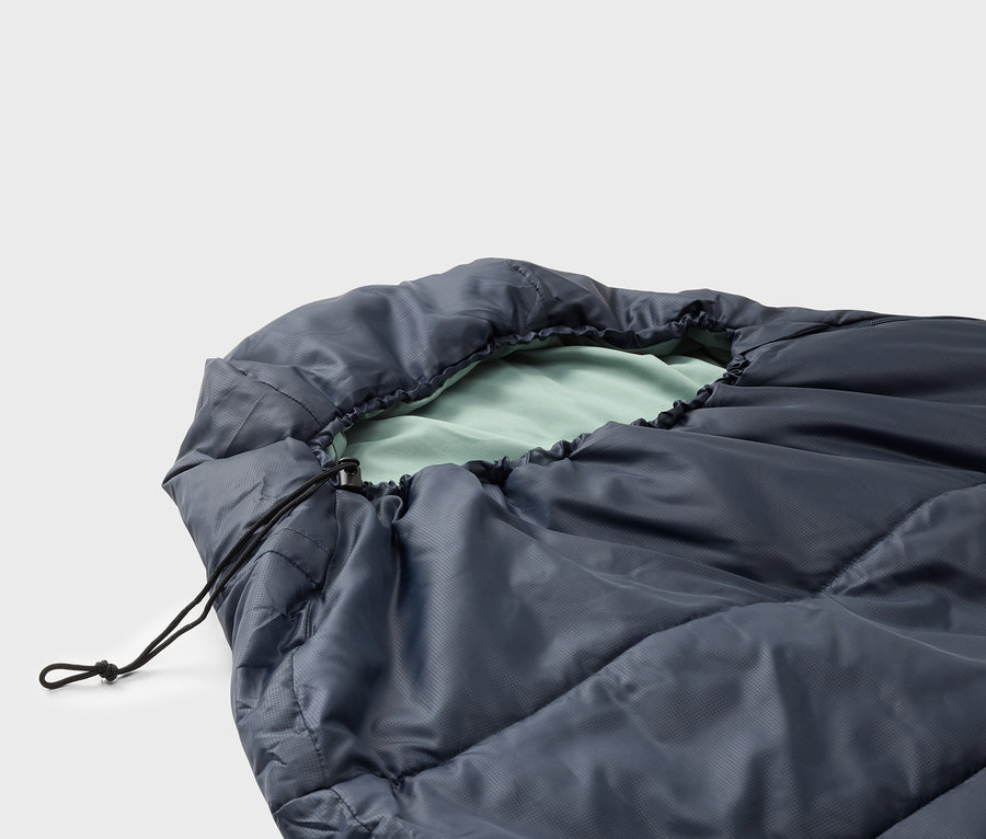 Nahaufnahme eines dunkelblauen Schlafsacks mit hellgrünem Innenfutter und einem schwarzen Kordelzug.