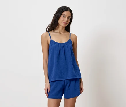 Frau trägt blaues Top und Shorts.