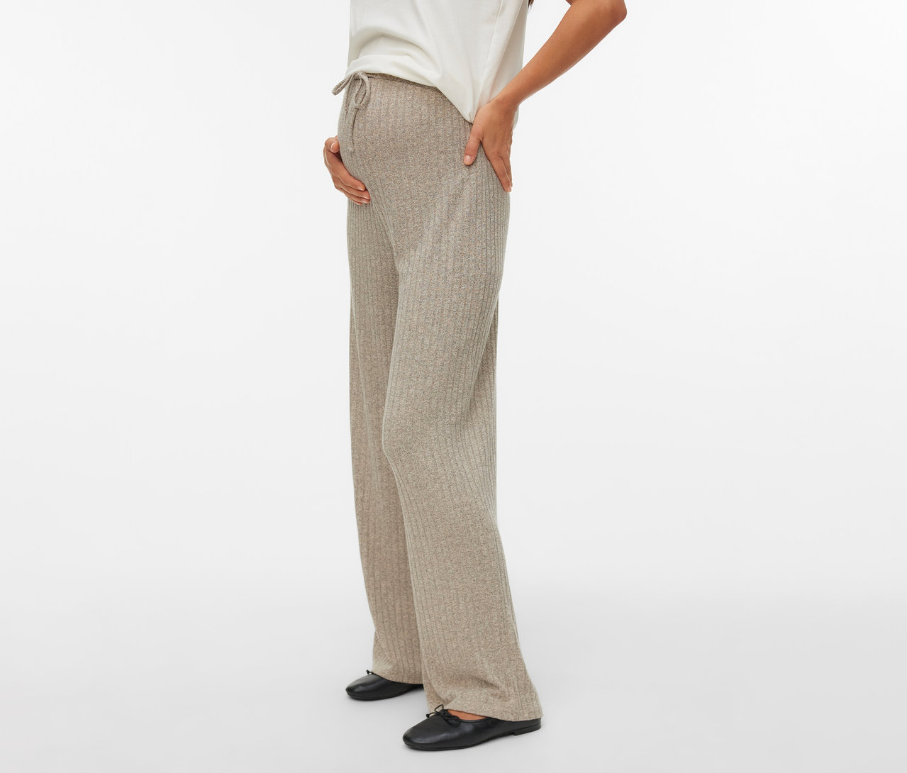 Schwangere mit MAMALICIOUS Loosefit Hose »MLPAMMIE«, weißem T-Shirt und schwarzen Schuhen, Hand auf Bauch.