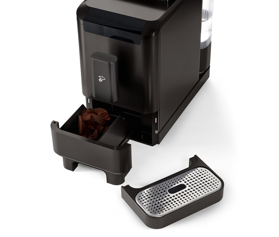 Detailaufnahme des »Esperto2 Caffè« Kaffeevollautomaten in Granite Black mit herausgezogenem Kaffeesatzbehälter und Abtropfschale.