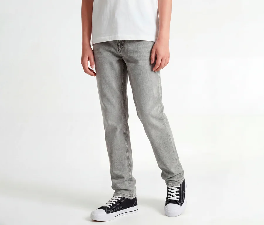 Stehende Person in weißem T-Shirt, grauen Jack&Jones JJOriginal Chris Jeans und schwarzen Sneakers.
