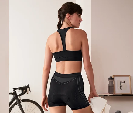 Frau in schwarzer Sportbekleidung trägt eine Radunterhose.