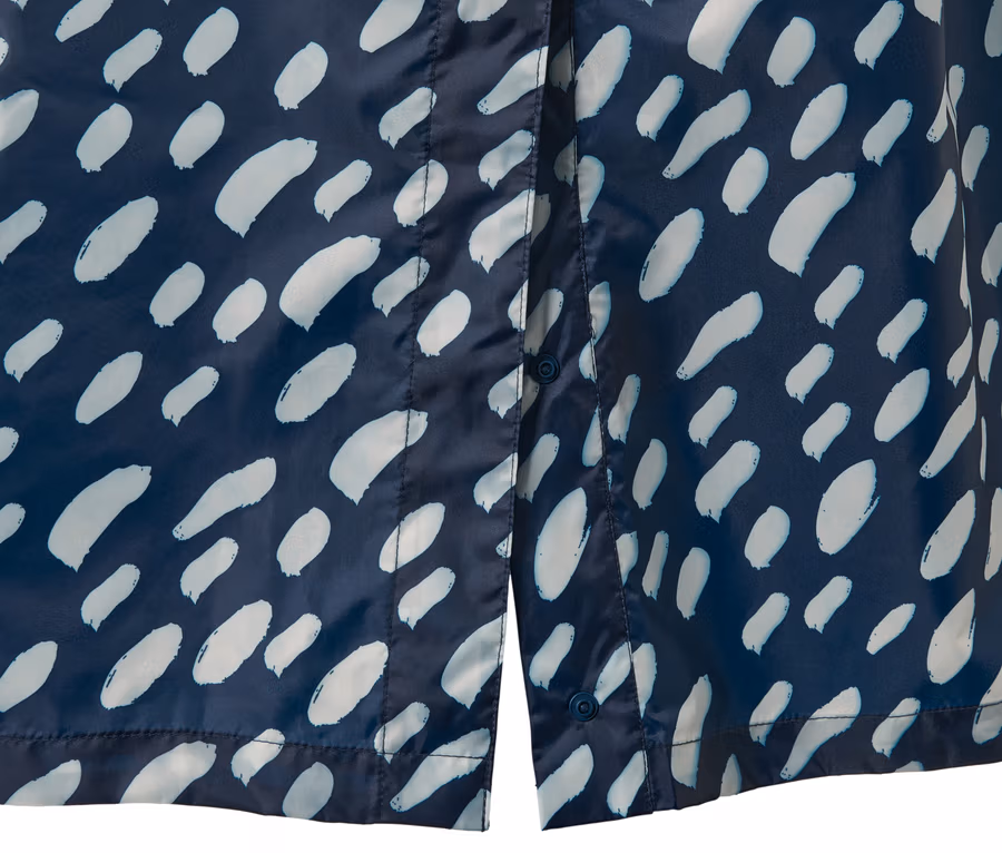 Detailansicht eines blauen Regenponchos mit Ärmeln und hellem Muster.