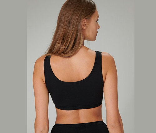 Rückansicht einer Frau mit braunen Haaren, die ein schwarzes 2 SCHIESSER Bustiers mit Bio-Baumwolle trägt.