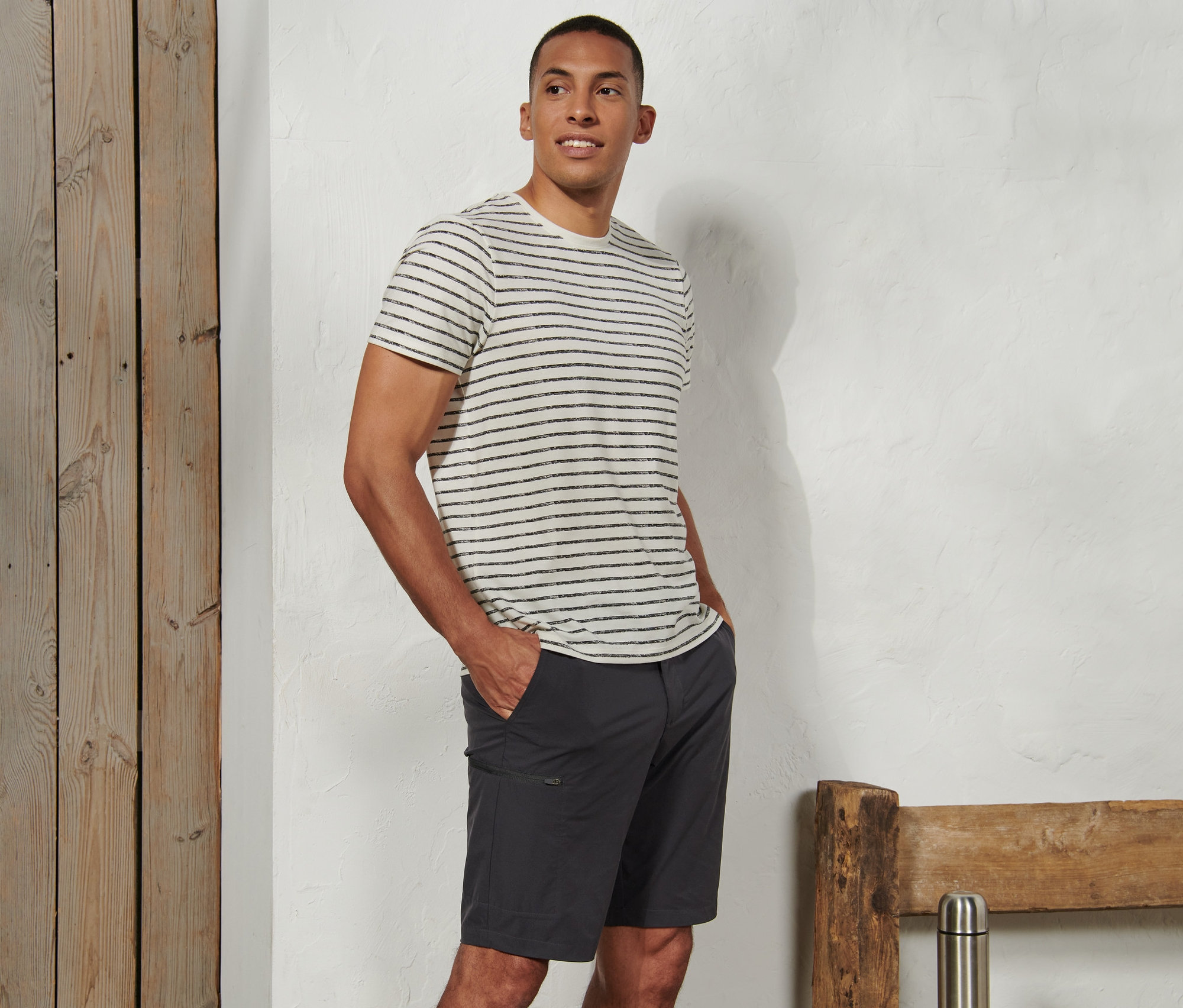 Ein Mann steht mit den Händen in den Taschen seiner Softshell-Funktionsshorts.