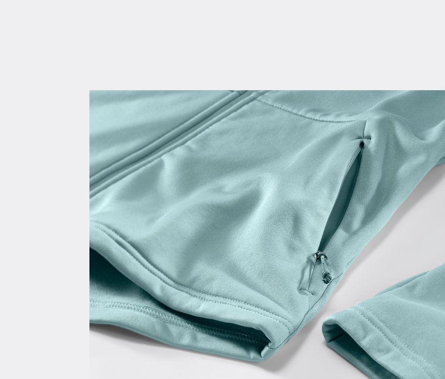 Detailansicht einer hellblauen Thermojacke mit Reißverschlusstasche und Ärmel.