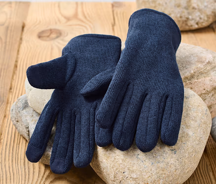 Dunkelblaue Strickfleece-Handschuhe liegen auf Steinen auf einer Holzoberfläche.