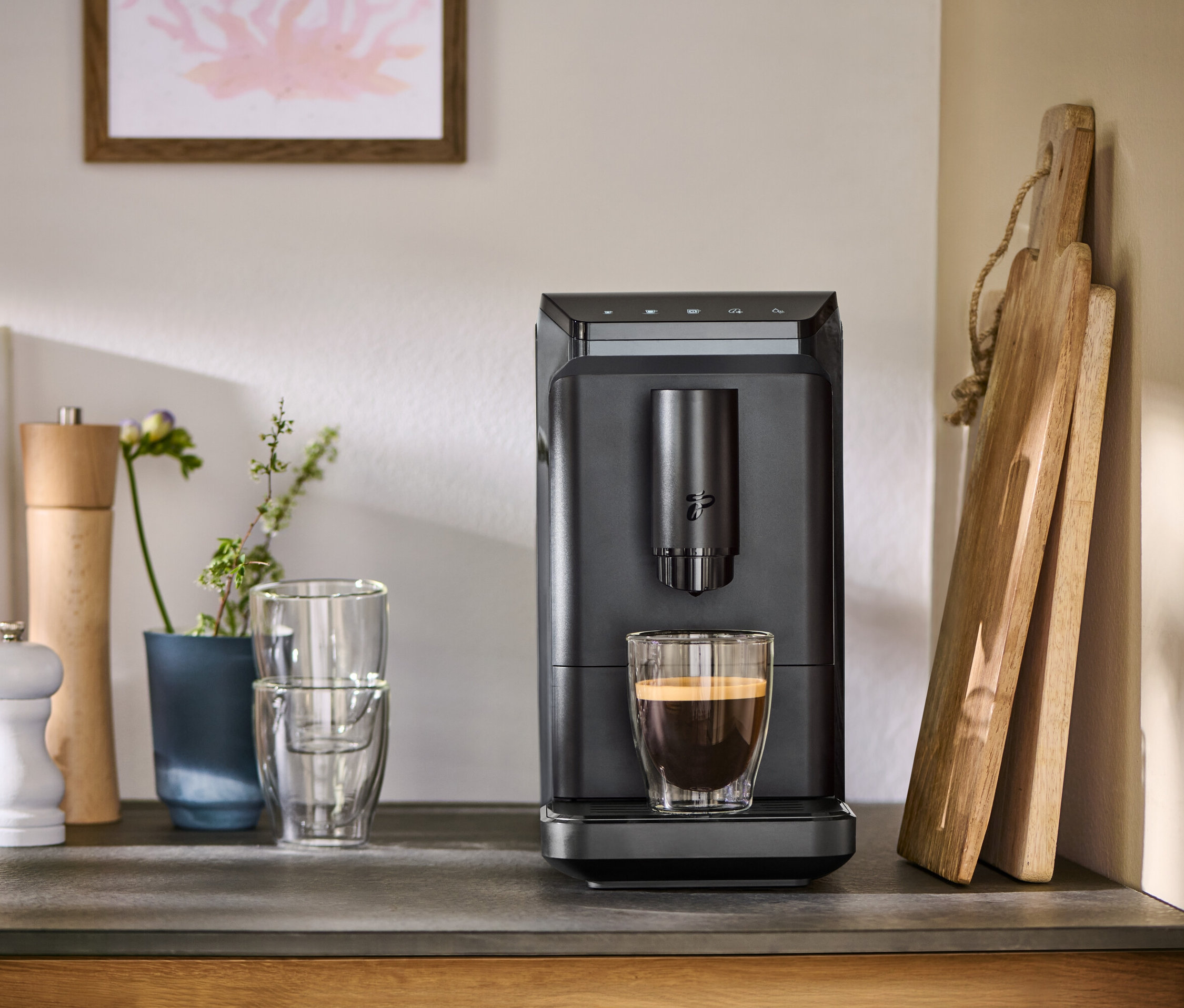 Graue »Esperto mini« mit einer Tasse Kaffee auf einer Theke.