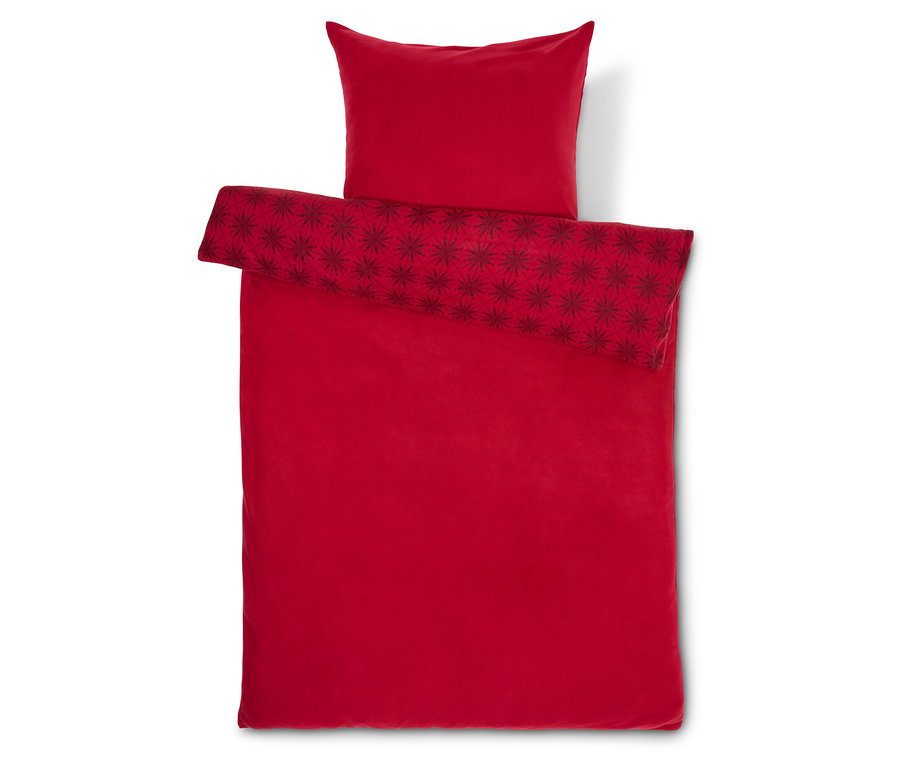 Rote Bettwäsche mit Sternen und Kissen.