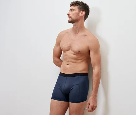 Mann steht mit Händen hinter dem Rücken, trägt eine blaue 2 Sport-Slipboxer.