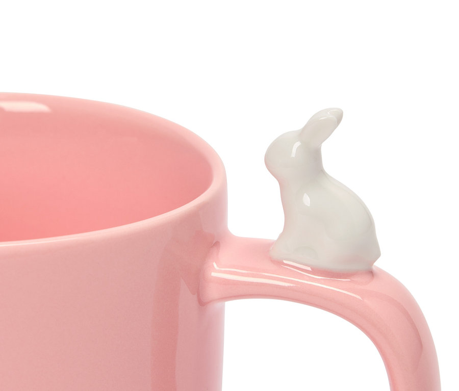 Nahaufnahme einer rosafarbenen Tasse mit einem weißen Hasen am Henkel.