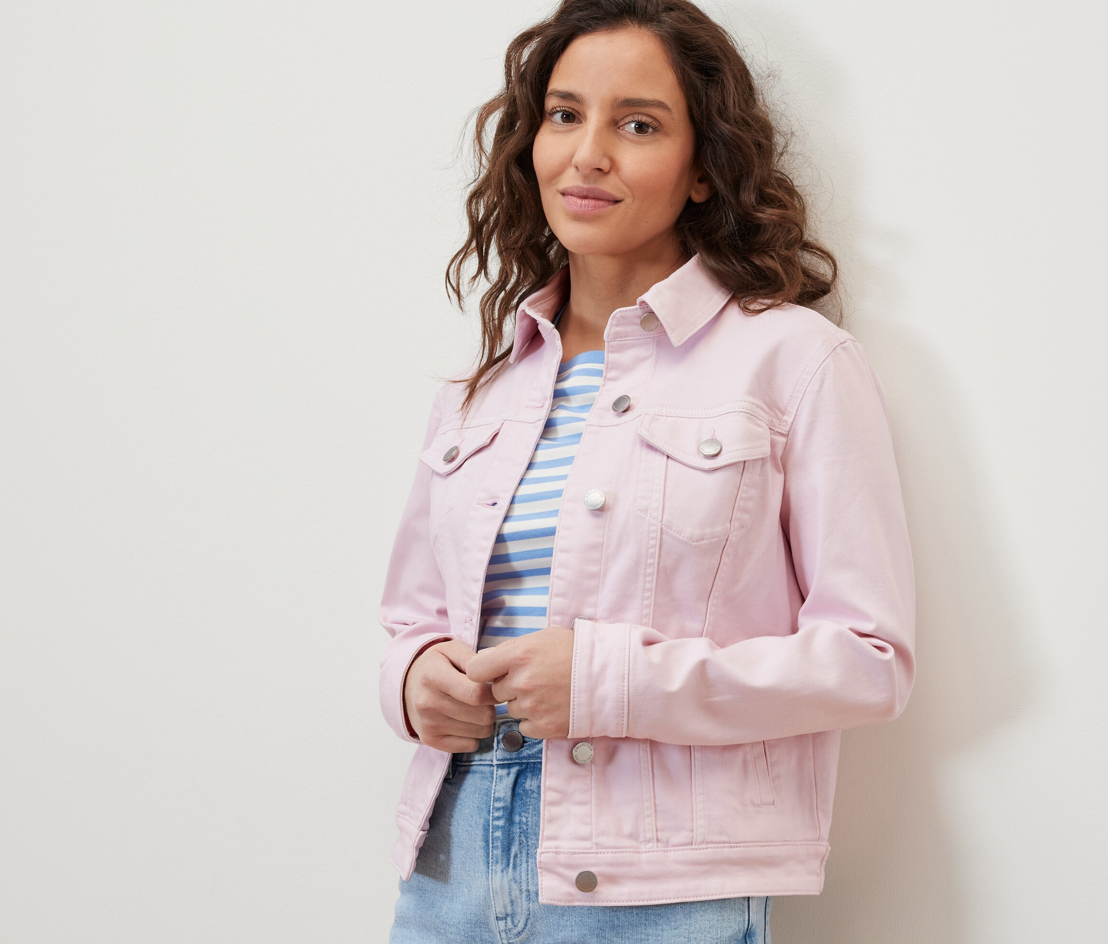 Frau trägt eine Jeansjacke und ein gestreiftes T-Shirt.