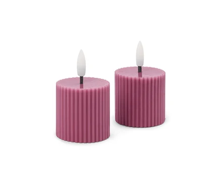 Zwei kurze, zylindrische, gerippte LED-Kerzen in Dunkelrosa mit weißen Flammen auf weißem Hintergrund.