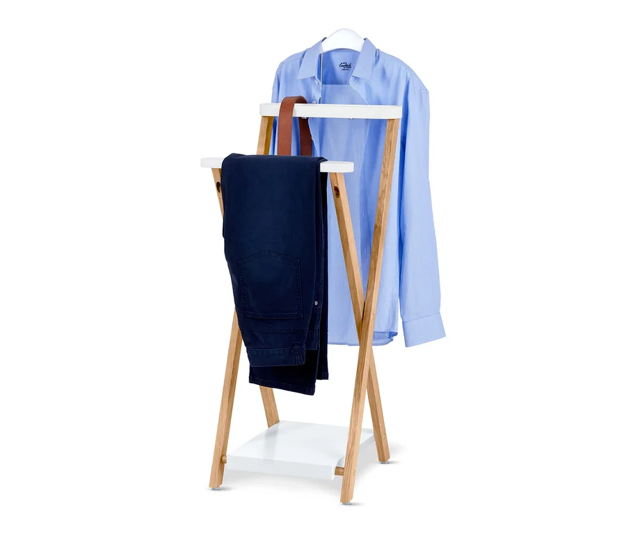 Auf einem Ständer hängen ein blaues Hemd auf einem Bügel und eine dunkelblaue Hose.