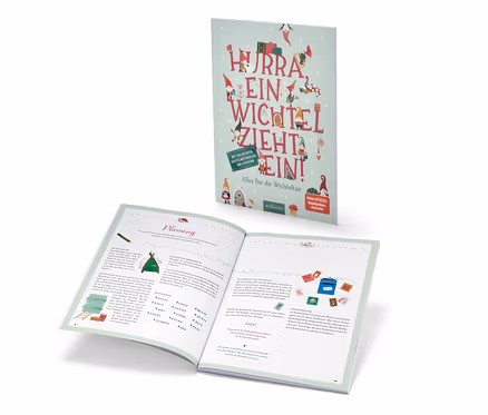 Das Buch »Hurra, ein Wichtel zieht ein!« ist geöffnet und steht dahinter.