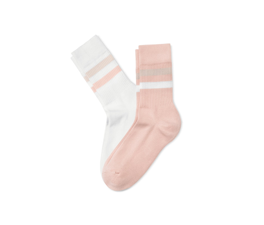 Zwei Paar Rippstrick-Socken, ein Paar rosé und ein Paar weiß.