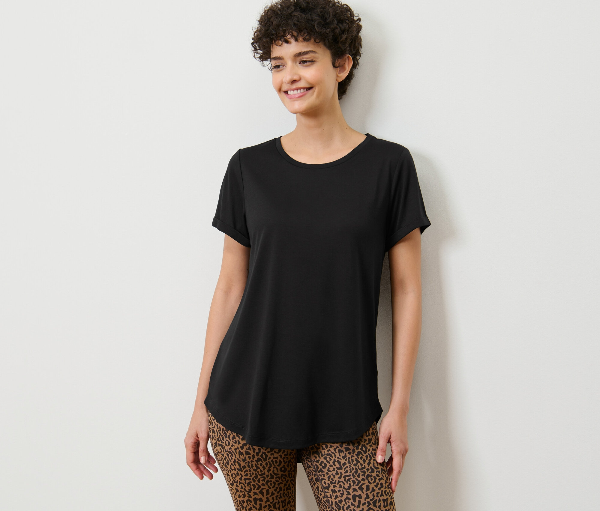 Frau posiert in einem schwarzen Longshirt.