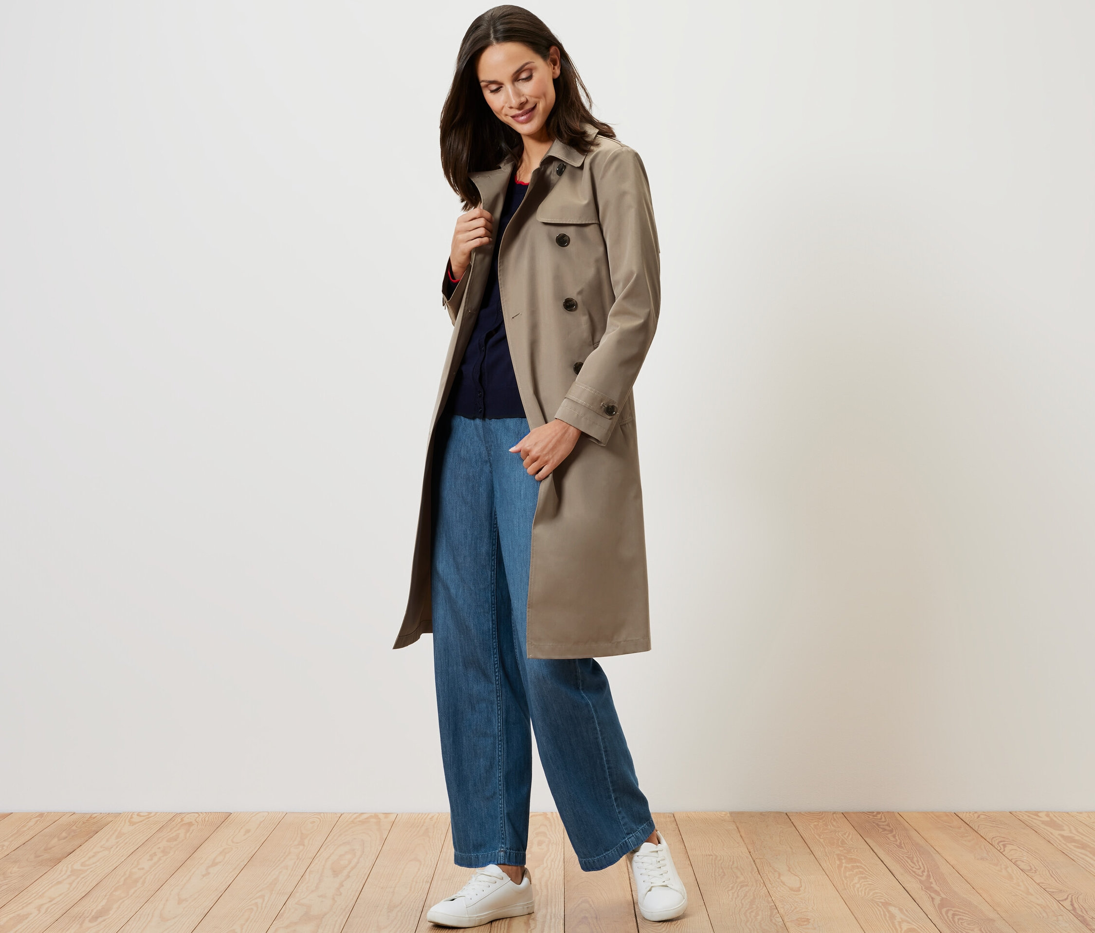 Frau trägt einen beigen Trenchcoat.