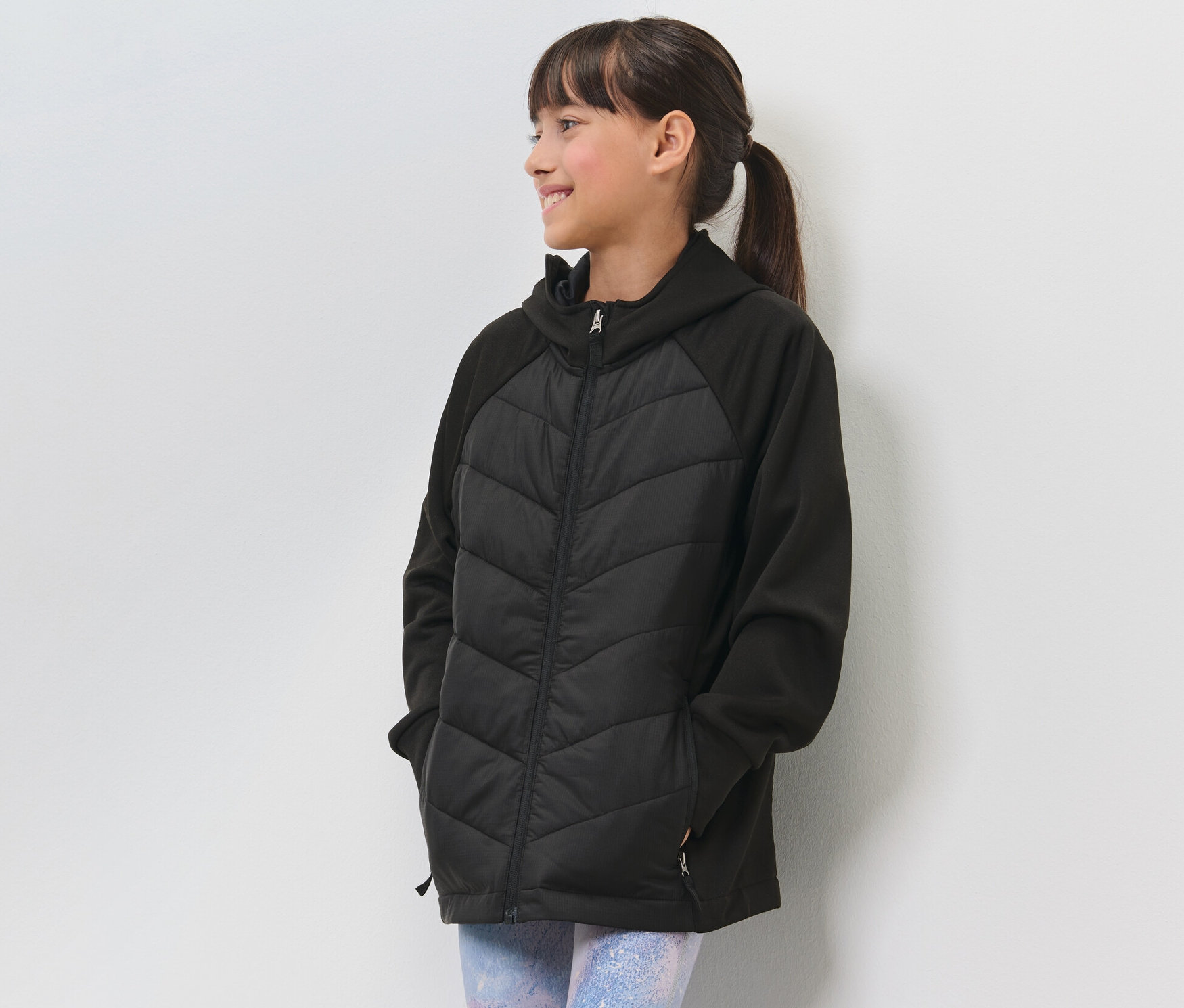 Mädchen in schwarzer Kinder-Thermo-Sportjacke.