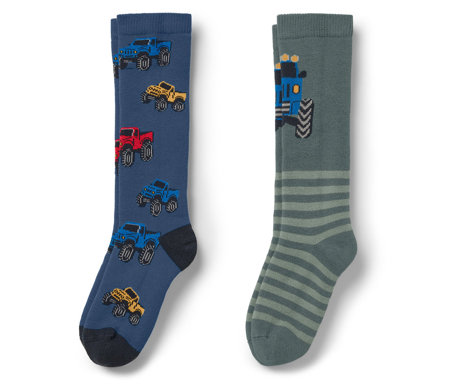 Zwei Socken: eine blaue mit Autos und eine graue mit Streifen und einem Traktor.