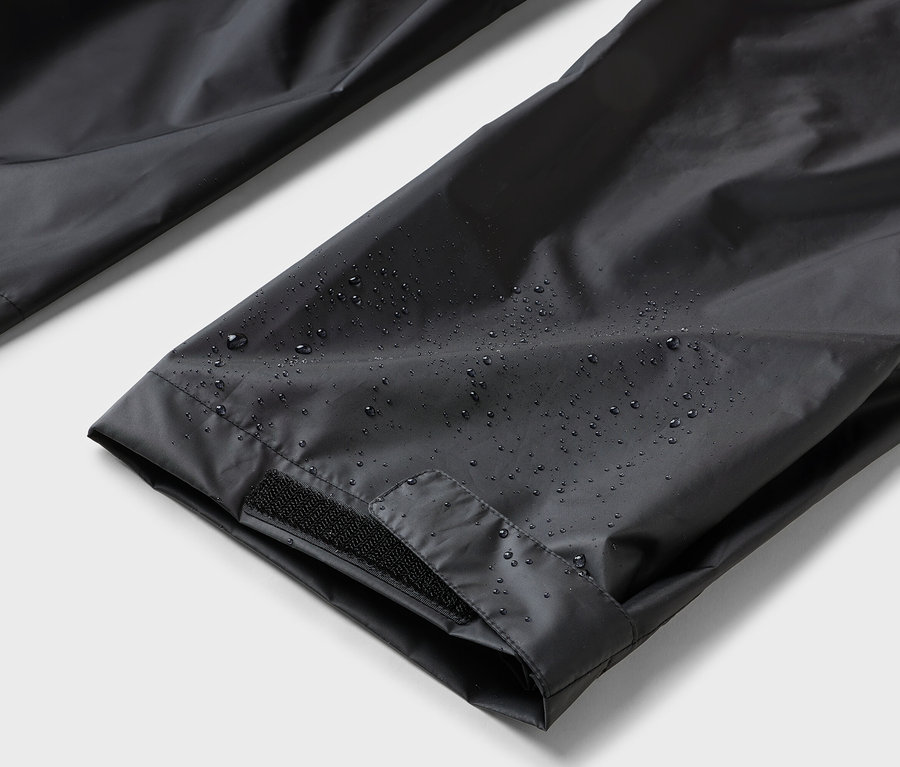 Nahaufnahme von wasserabweisenden schwarzen Hosen mit Klettverschluss.