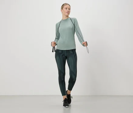 Frau in Sportbekleidung hält ein Springseil in den Händen.