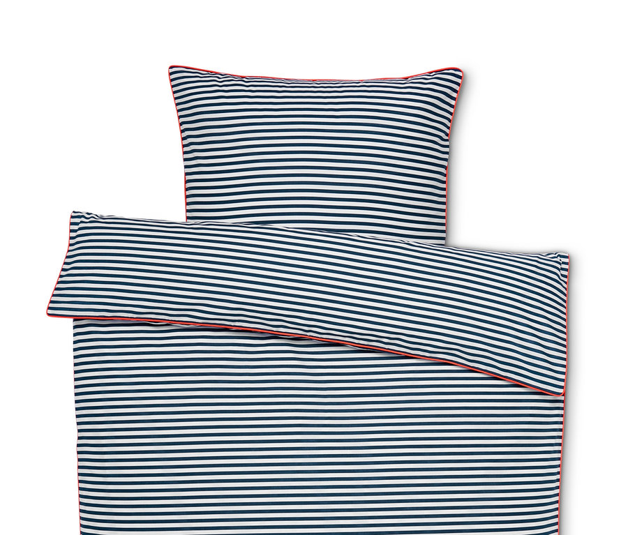 Draufsicht auf eine ausgebreitete Renforcé-Bettwäsche mit blauen und weißen Streifen und roter Paspel.