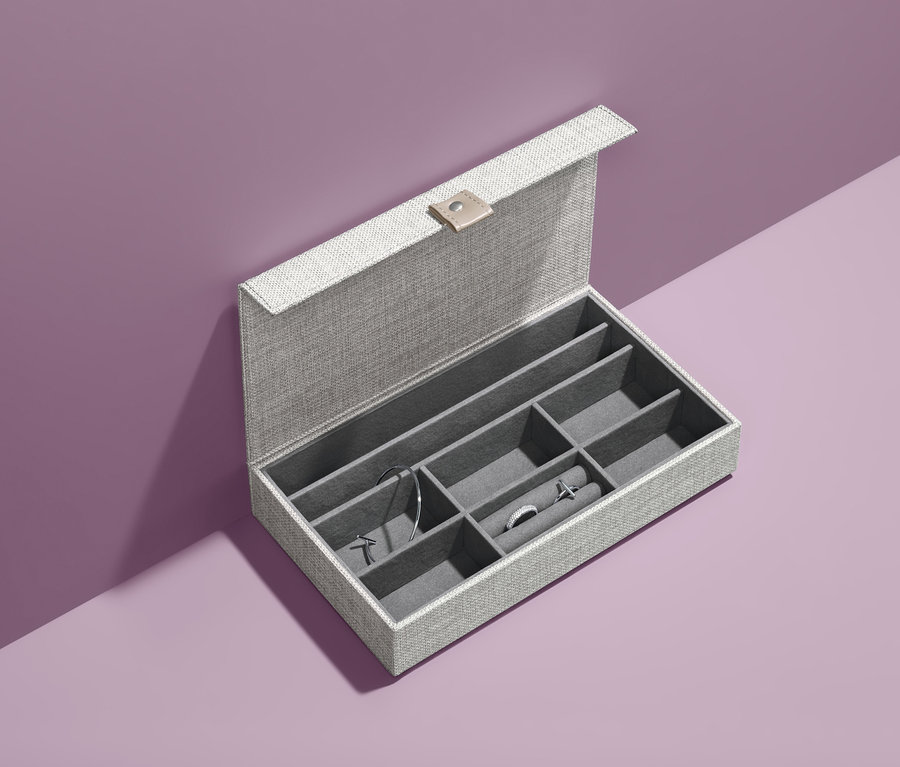 Geöffnete Aufbewahrungsbox für Schmuck mit Schmuck auf violettem Hintergrund.