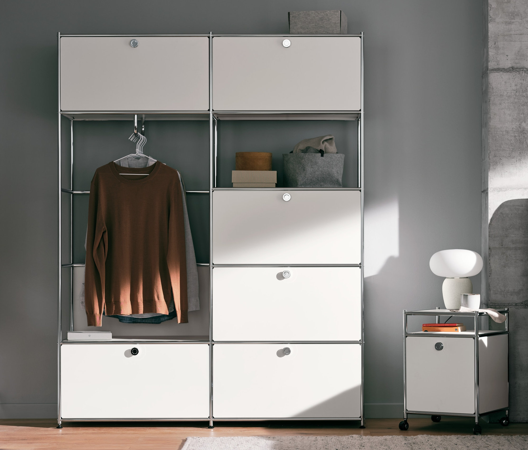 Schlafzimmer mit Systemschrank Metall »CN3« in Weiß, Rollcontainer Metall »CN3« mit Klappe in Weiß und Tischleuchte mit Glasschirm.