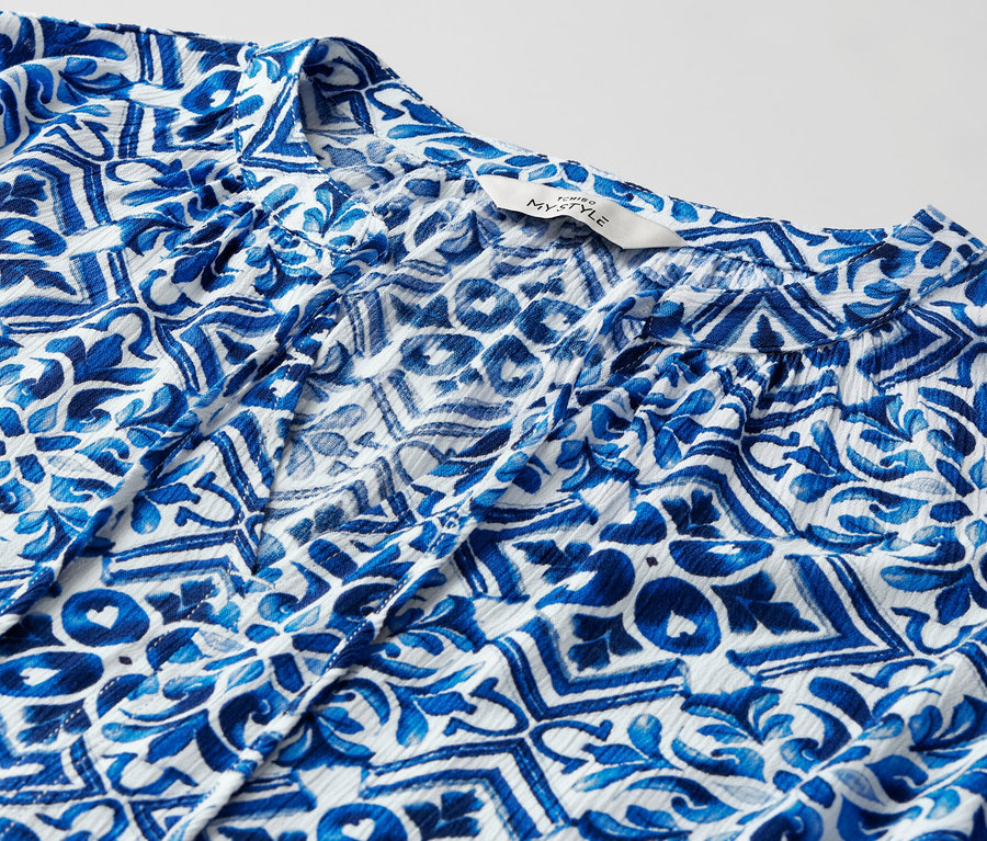 Detailansicht einer blau bedruckten Tunika-Bluse.