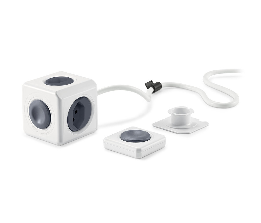 Weißer Steckdosenwürfel mit Fernbedienung und Kabel.