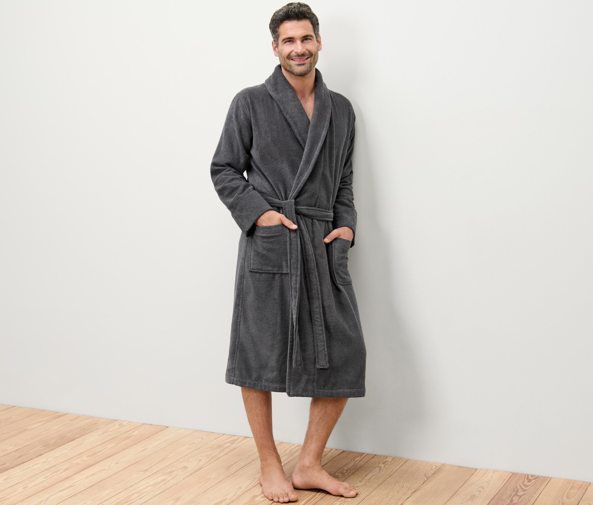 Mann steht und trägt einen Bademantel.