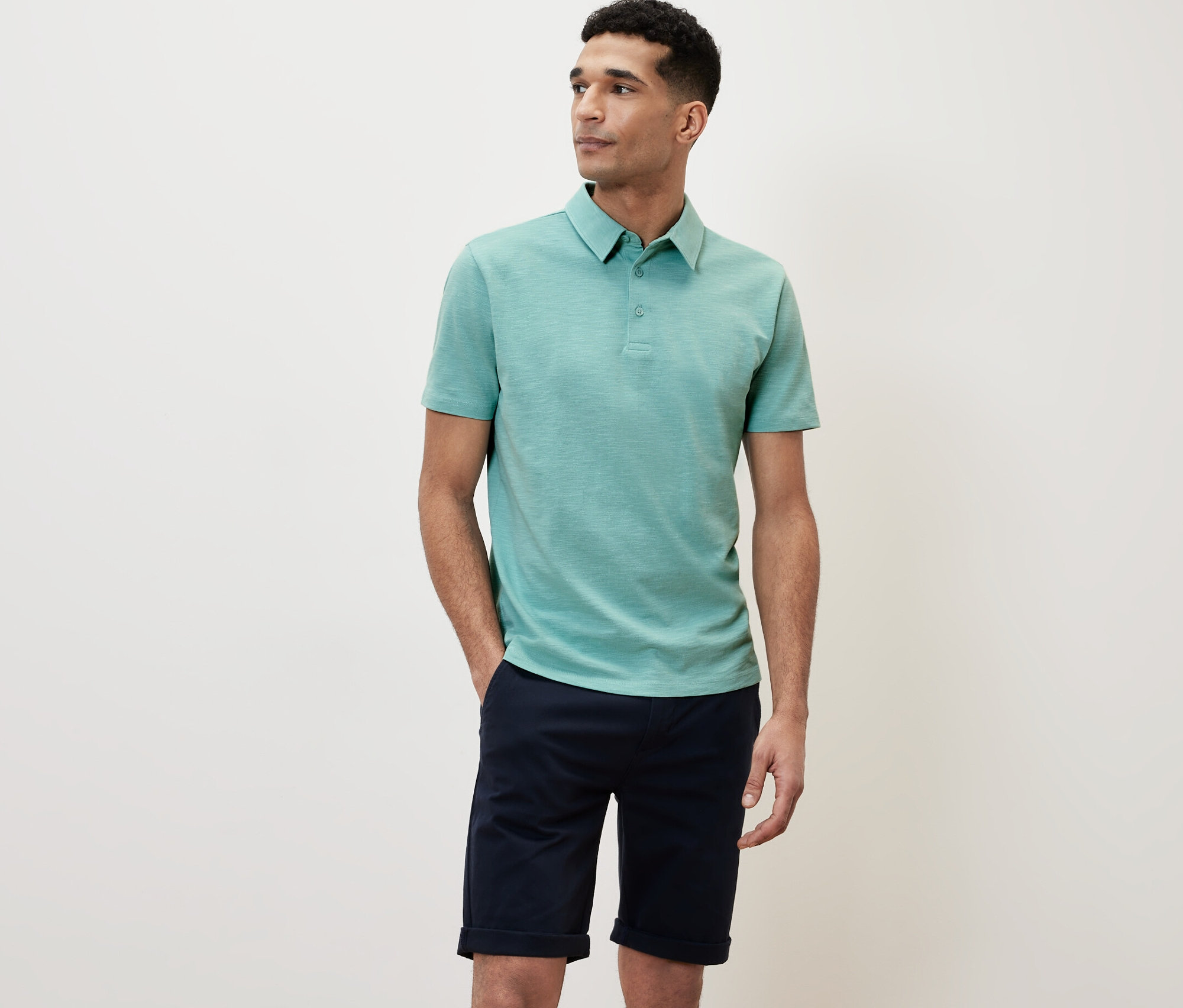 Mann trägt ein grünes Poloshirt.