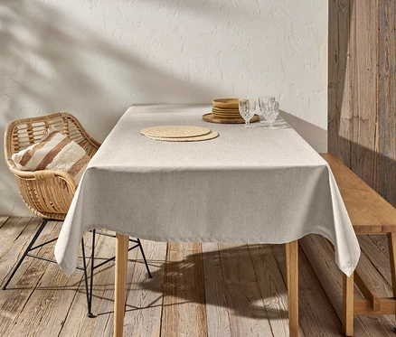 Abwischbare Tischdecke liegt auf dem Tisch. Auf dem Tisch stehen Teller und Gläser. Ein Stuhl und eine Bank stehen am Tisch.