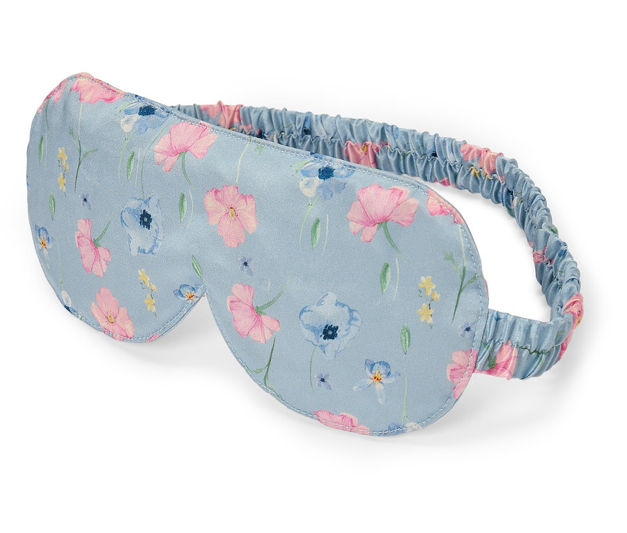 Eine hellblaue Schlafmaske mit Blumenmuster.