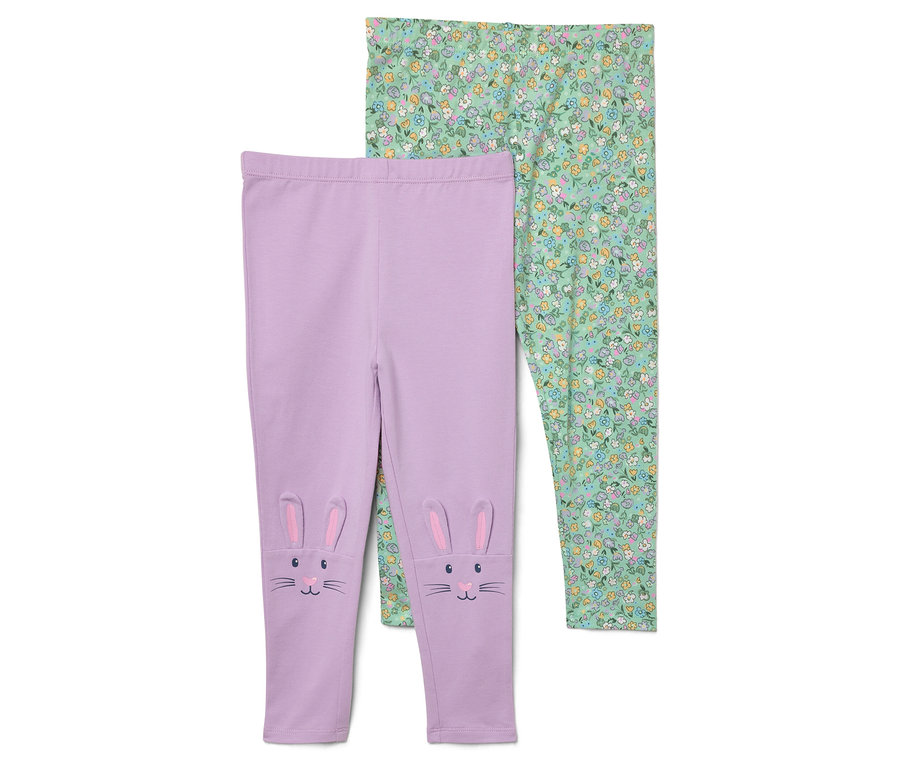 Zwei Leggings. Eine lila Leggings mit Hasenohren und Gesicht auf den Knien und eine grüne mit Blumenmuster.