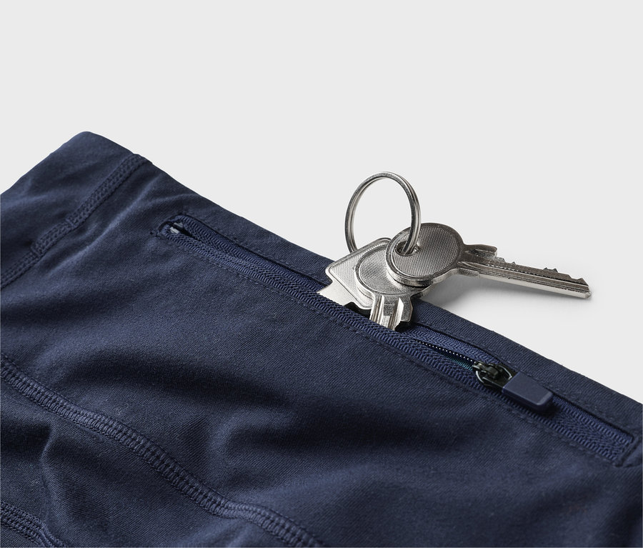 Nahaufnahme einer marineblauen Hose mit einem Schlüsselbund im Reißverschlussfach.