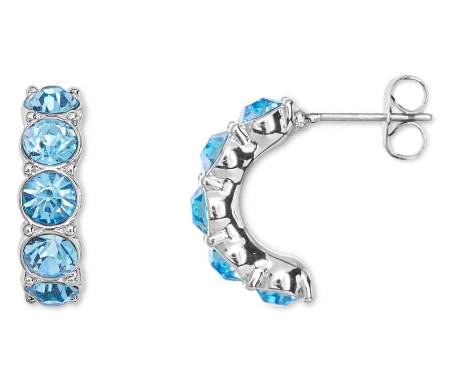Nahaufnahme von einem Paar silberner Ohrringe mit jeweils fünf hellblauen Steinen.