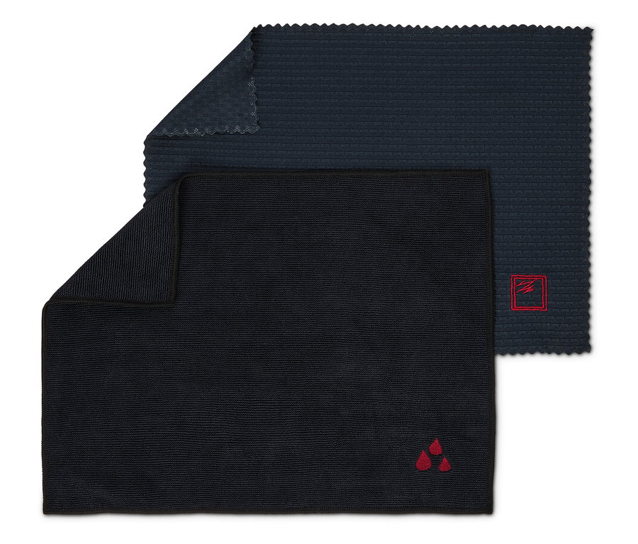 Zwei dunkle Reinigungstücher, eines mit einem roten Logo mit drei Tropfen und das andere mit einem roten Logo in einem Quadrat.