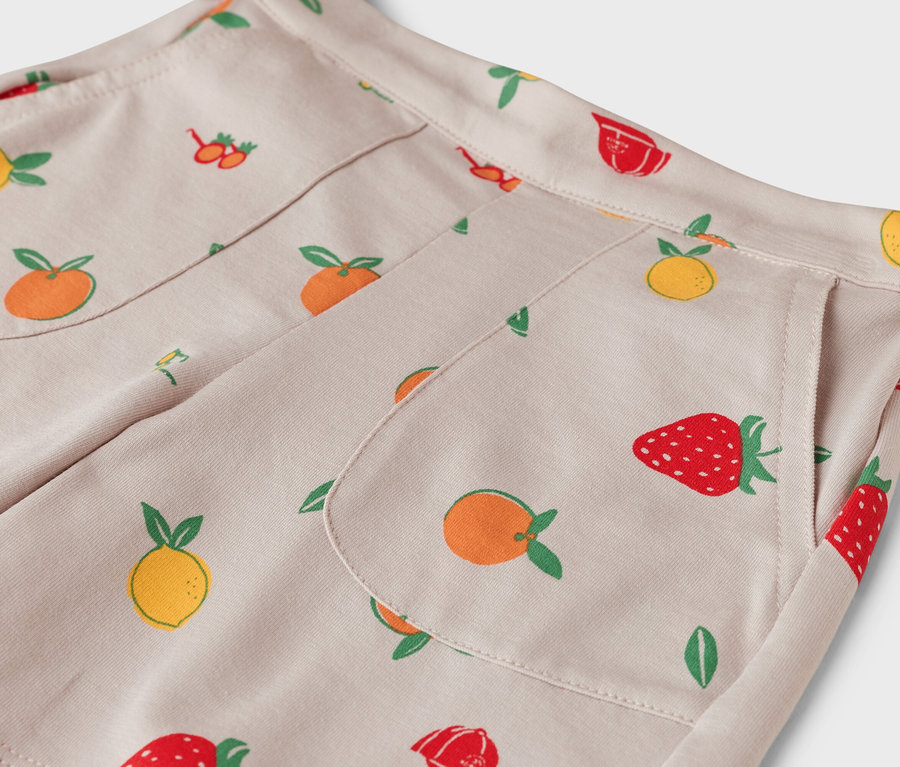 Nahaufnahme einer beigen Hose mit Fruchtmuster.