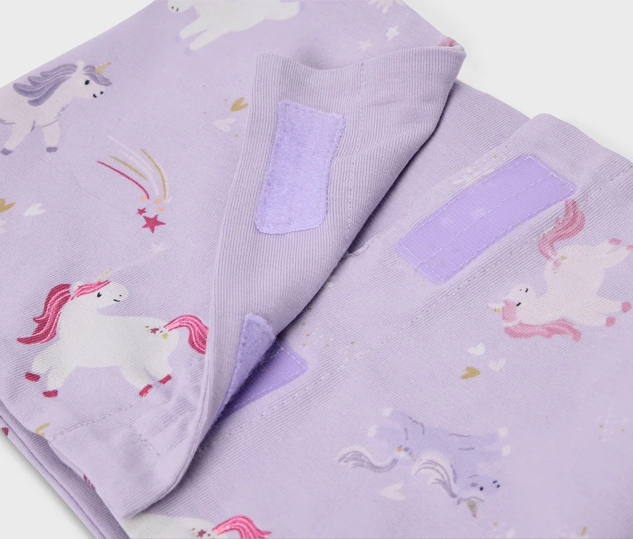 Nahaufnahme von lila Stoffwindeln mit Einhornmuster und Klettverschluss.
