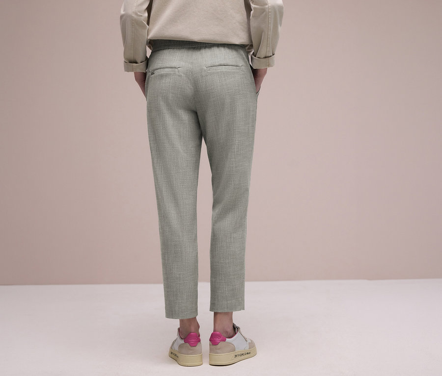 Person von hinten in hellgrünen Street One Joggpants und beigen Sneakers mit pinken Akzenten.