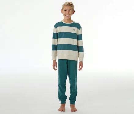 Lächelnder Junge in einem SCHIESSER Kinder-Interlock-Pyjama mit gestreiftem Oberteil in Petrol und Creme und petrolfarbener Hose.