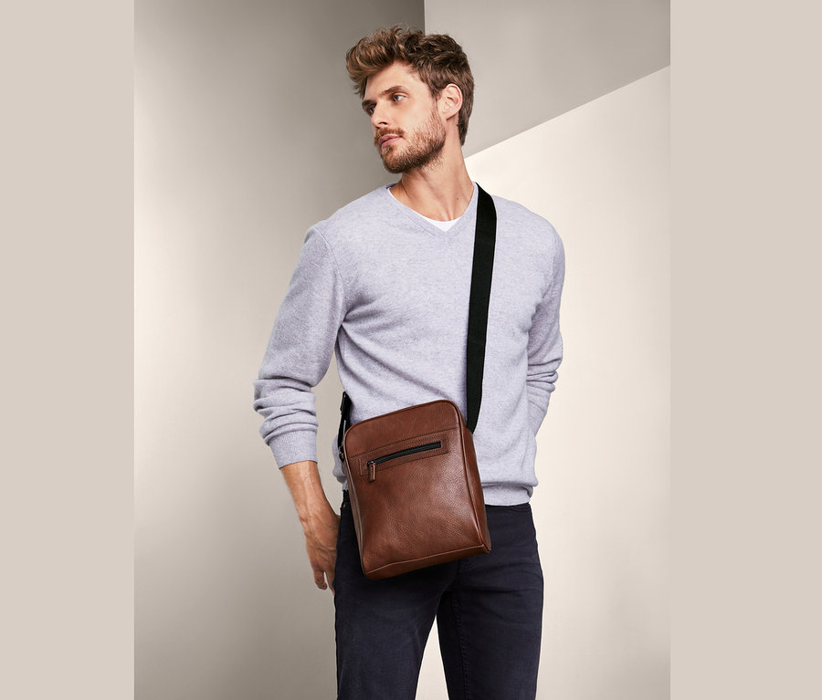 Mann posiert mit Leder-Crossbag.