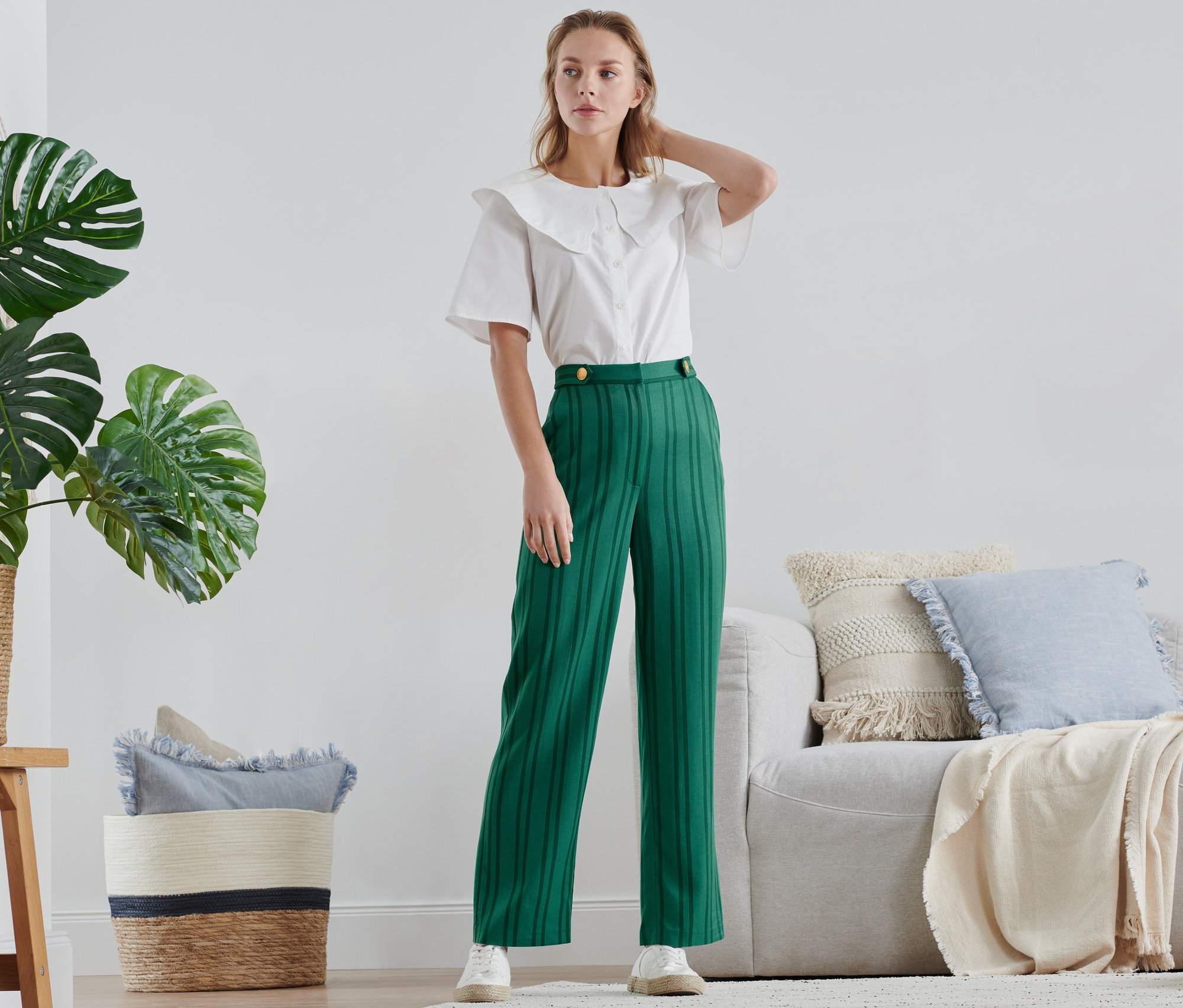 Frau posiert in einer gestreiften Hose.