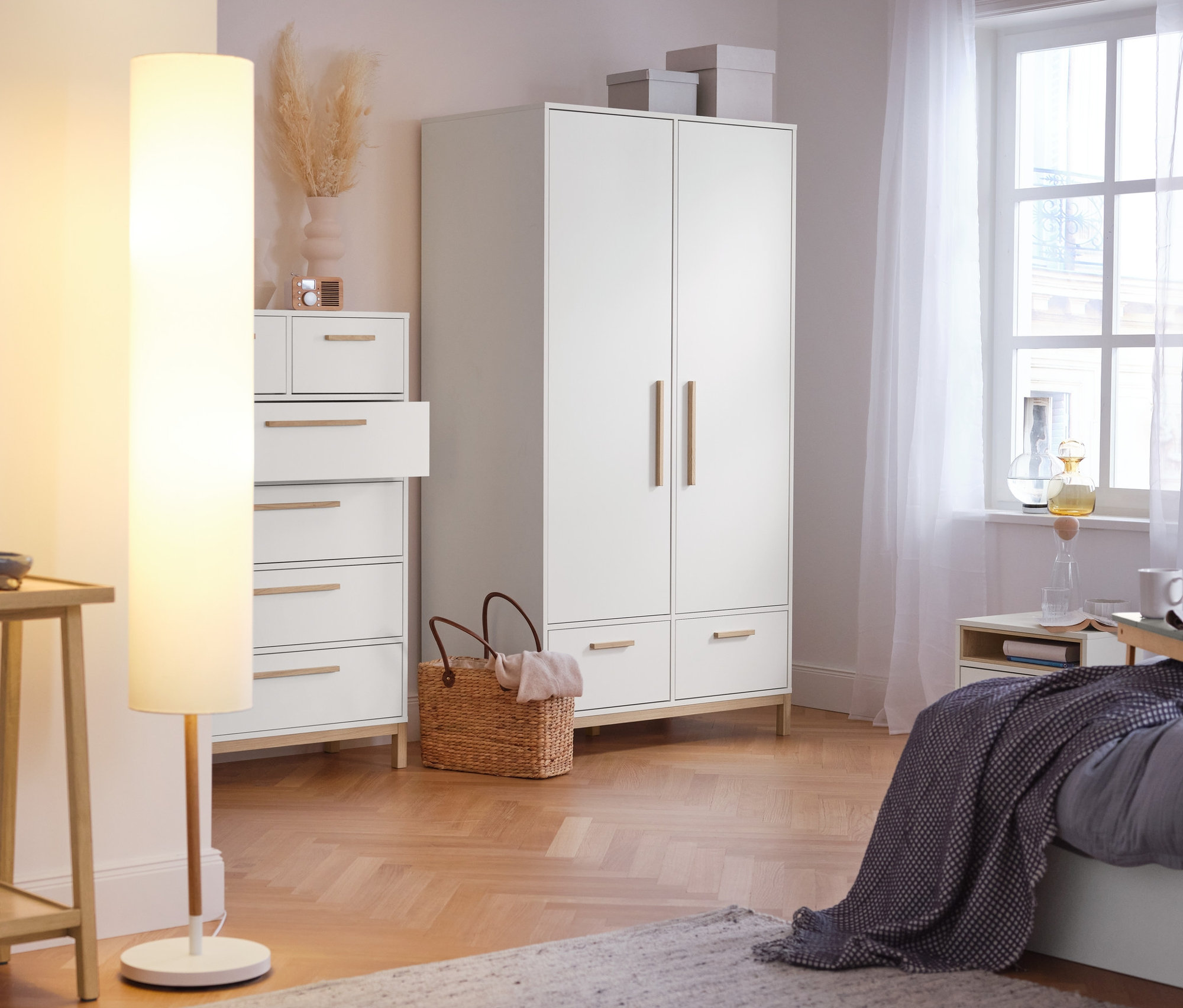 Im Schlafzimmer stehen ein Konsolentisch mit 2 Ablagen, eine Stehleuchte mit Textilschirm, ein Highboard »Eklund« mit Schubladen und ein Kleiderschrank »Eklund« mit Schubladen.