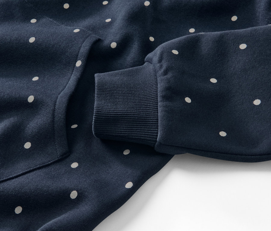 Detailaufnahme eines marineblauen Loungewear-Kleids mit weißen Punkten.