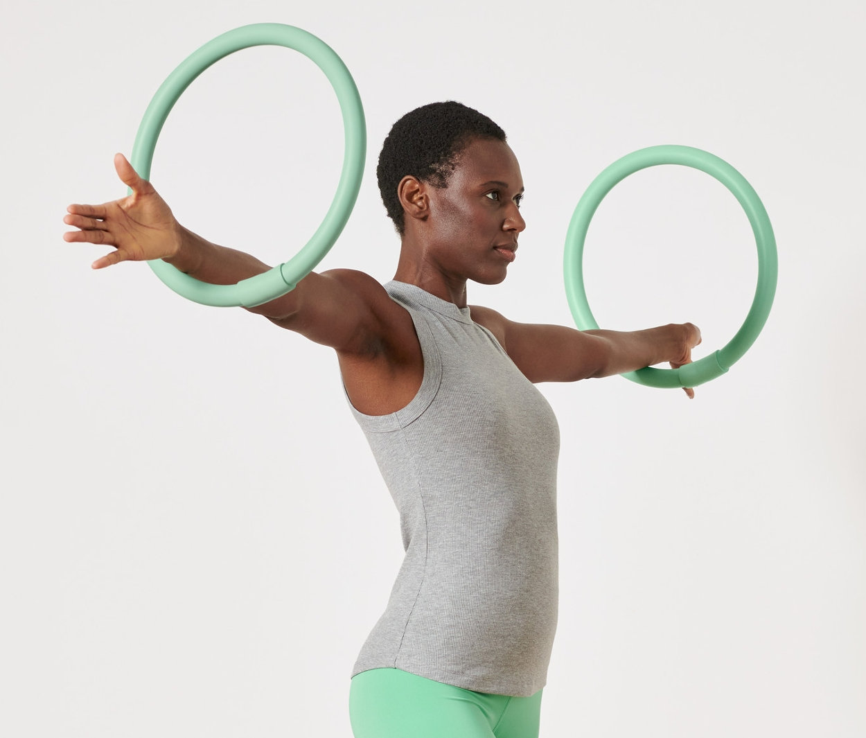 Frau trainiert mit 2 Arm-Trainingsreifen.