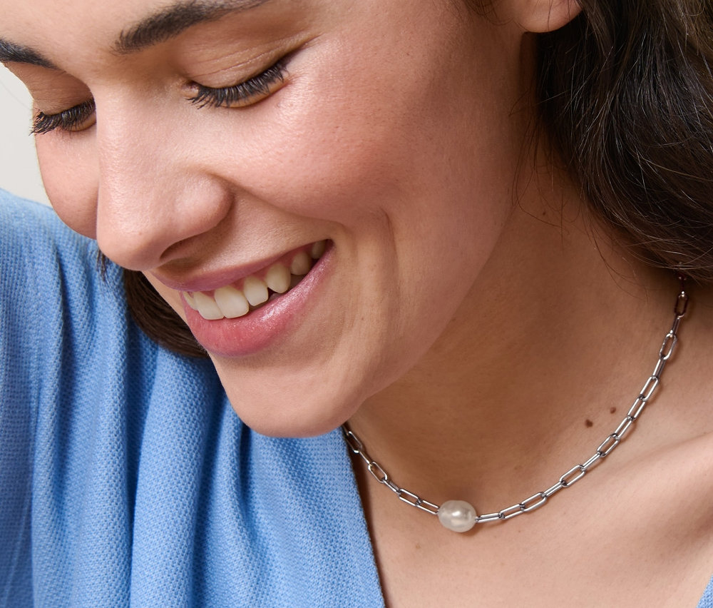 Lächelnde Frau mit Kette mit Perle.